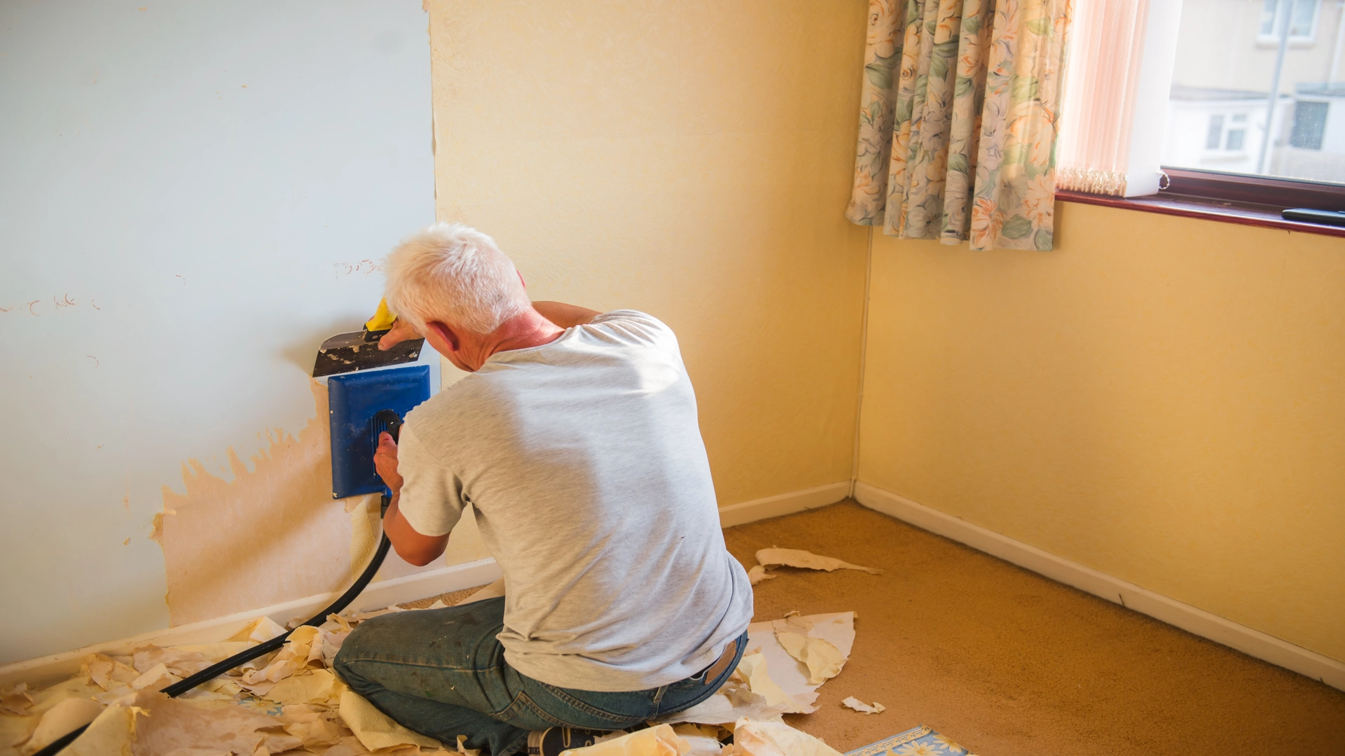  a man removing wallpaper 