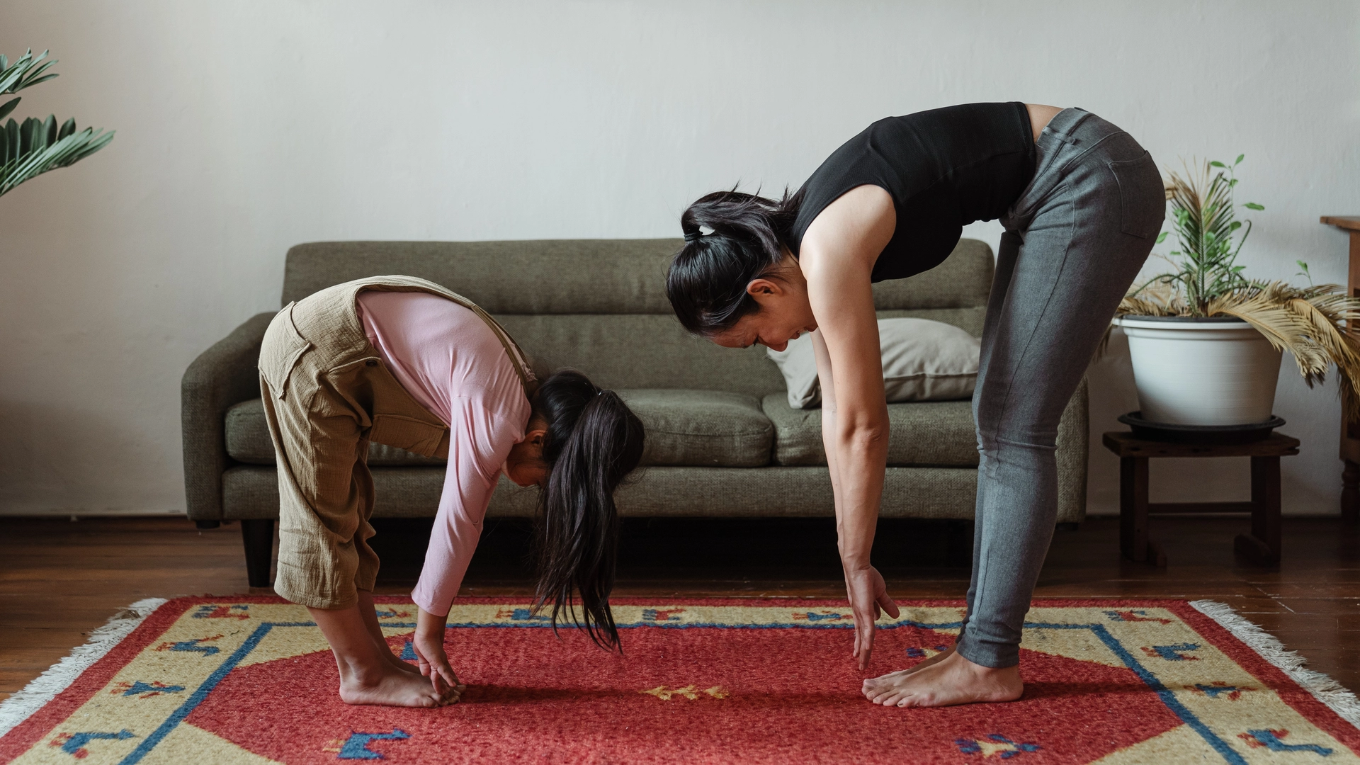 A girl and her mother doing their daily morning routine exercise at home